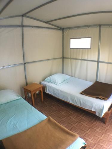 Habitación con 2 camas y mesa. en Camping Paleokastritsa, en Paleokastritsa