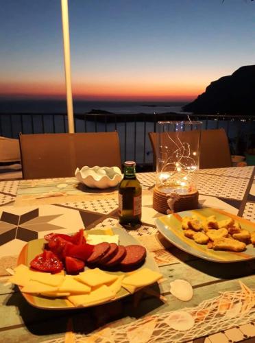 a table with two plates of food on top of a balcony at Elsa's house in Kalymnos