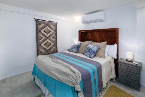 een slaapkamer met een bed met een houten hoofdeinde bij Villa Robalo A in Sayulita