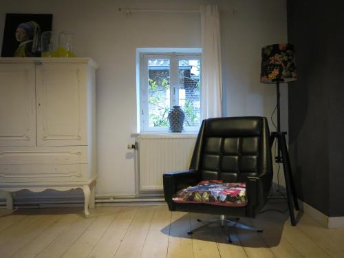 a black chair in a room with a window at SintPieter17 Lo-Ghis vakantiewoning in Voeren