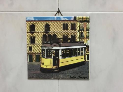 een foto van een gele bus voor een gebouw bij Casa da Mariquinhas in Lissabon