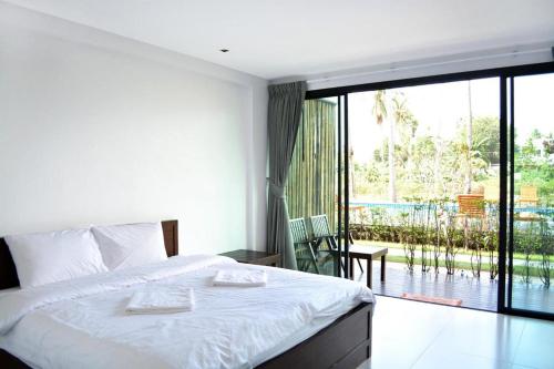 um quarto com uma cama e uma grande janela de vidro em The Nidhra Boutique Resort em Ban Tai
