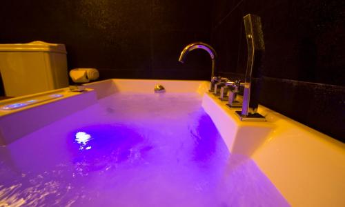 a bathroom with purple lights in a sink at The Firs in Nuwara Eliya