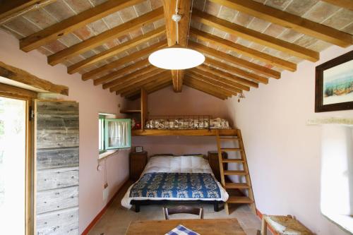 1 dormitorio con 1 cama en una habitación con techos de madera en I Poggi di Belvedere, en Cerbaiolo