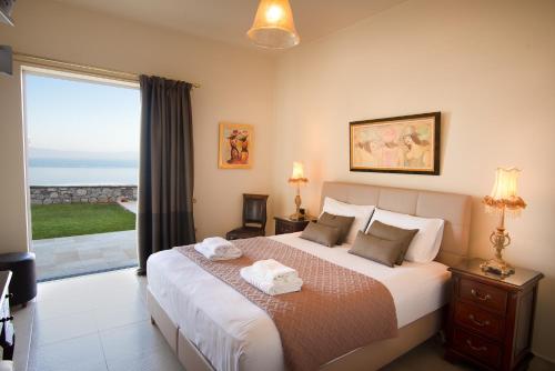 Un dormitorio con una cama grande y una ventana grande. en Villa Rebecca, en Kalamata