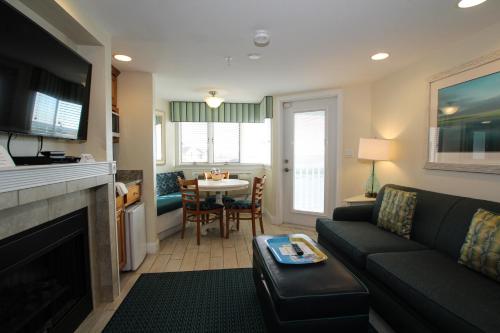 a living room with a couch and a table and a kitchen at Ocean Club on Smuggler's Beach in South Yarmouth