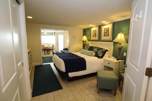 um quarto com uma cama e uma cadeira em Ocean Club on Smuggler's Beach em South Yarmouth