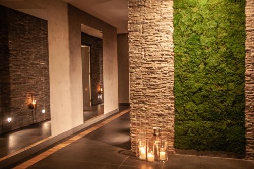 a hallway with a wall of plants and candles at Grand Nosalowy Dwór in Zakopane