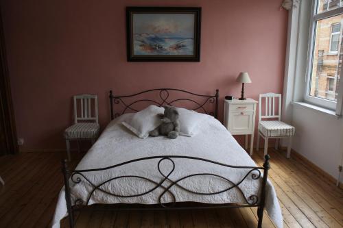 a teddy bear sitting on a bed in a bedroom at "Knokke-Guestroom" in center gives free bicycle use and is pet-friendly! No hidden costs! in Knokke-Heist