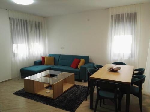 a living room with a blue couch and a table at Lovac apartmani in Zlatibor