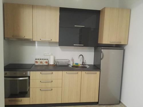 a kitchen with wooden cabinets and a stainless steel refrigerator at Lovac apartmani in Zlatibor