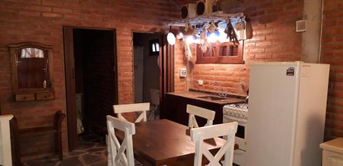 kuchnia ze stołem i białą lodówką w obiekcie Clima Serrano w mieście Merlo
