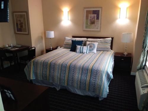 a hotel room with a bed and two lamps at Athens Hotel & Suites in Houston