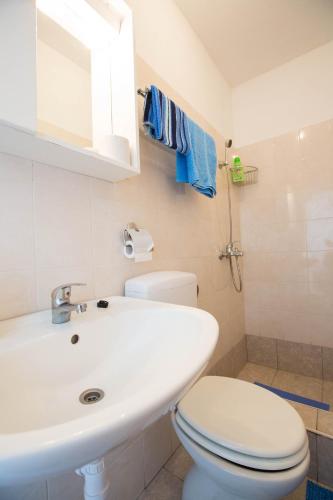 a white bathroom with a toilet and a sink at Holiday Home Ratac Sunshine Beach in Slano