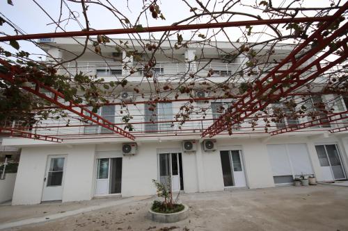 a building with white walls and red metal structures at Vila Nikezić in Sutomore