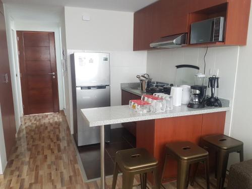 une petite cuisine avec un comptoir et des tabourets. dans l'établissement Lima Flats, à Lima