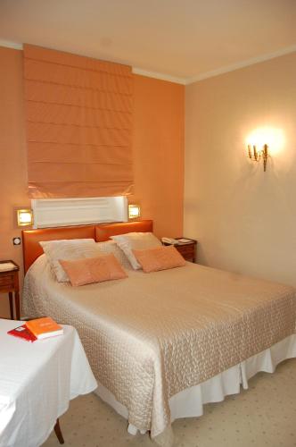 a bedroom with a large bed with orange walls at L'Esplanade in Domme