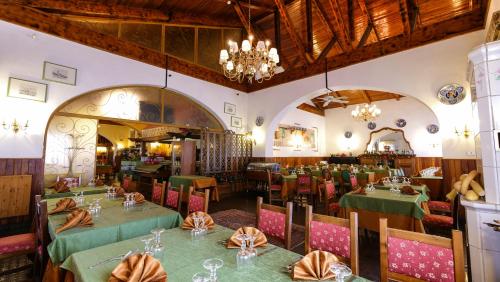 a dining room with tables and chairs and a chandelier at Hotel Ristorante La Nuova Fattoria in Carsoli