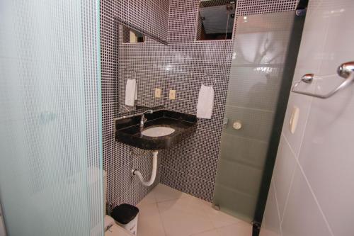 a bathroom with a black sink and a toilet at Pousada Maravilha in Ilha de Boipeba