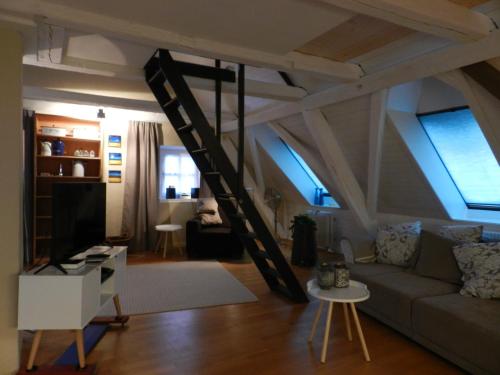 a living room with a couch and a ladder at Blue Wall BnB in Gebenstorf