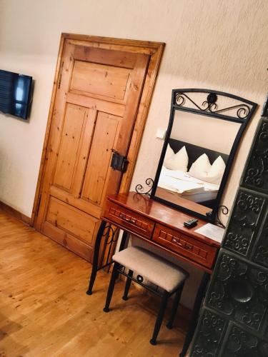 a bedroom with a mirror and a desk with a bed at Pension & Restaurant Atmosféra in Loket