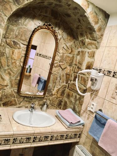 a stone bathroom with a sink and a mirror at Pension & Restaurant Atmosféra in Loket
