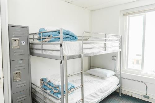 a bunk bed room with two bunk beds and a window at ITH Hermosa Beach Surf Hostel LAX in Hermosa Beach