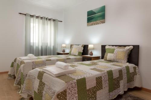 a bedroom with two beds with towels on them at Vivenda Golfinho Barra in Praia da Barra