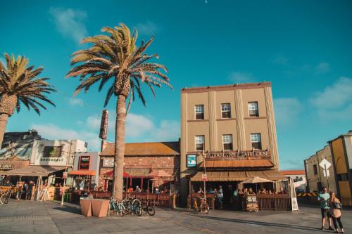 a palm tree and a building on a city street at ITH Hermosa Beach Surf Hostel LAX in Hermosa Beach