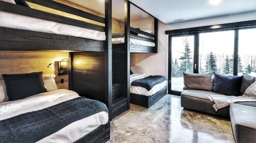 una camera con due letti a castello e un divano di Le Saint-Laurent - Résidences Boutique a Petite-Rivière-Saint-François