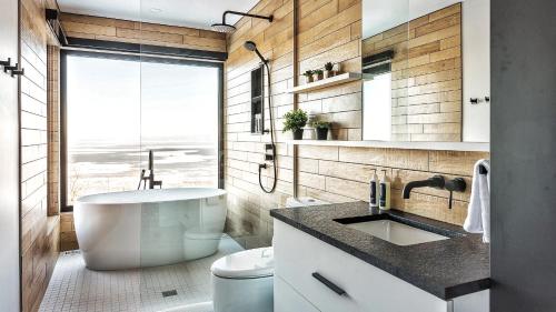 un bagno con una grande vasca e un lavandino di Le Saint-Laurent - Résidences Boutique a Petite-Rivière-Saint-François
