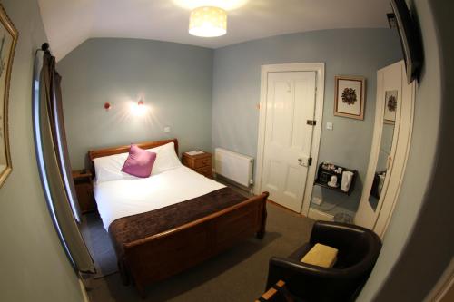 a small bedroom with a bed and a chair at Rolling Wave Guesthouse in Bundoran