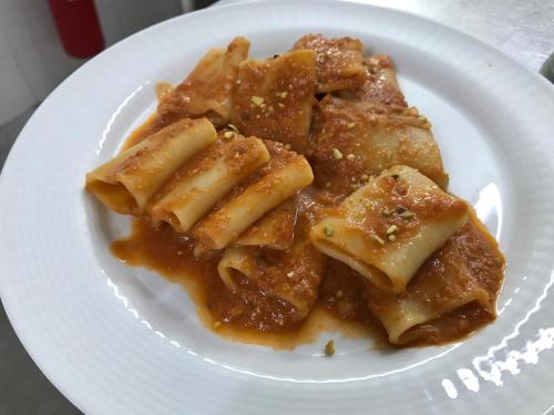 a white plate of pasta with sauce on it at Hotel La Fattoria Sul Mare in Capo Vaticano