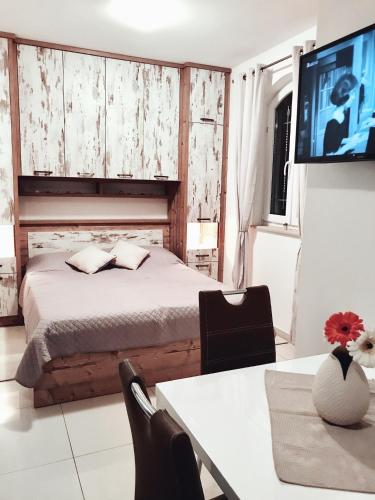 a bedroom with a bed and a tv on a wall at J&B - Beachside Studio Apartment in Makarska
