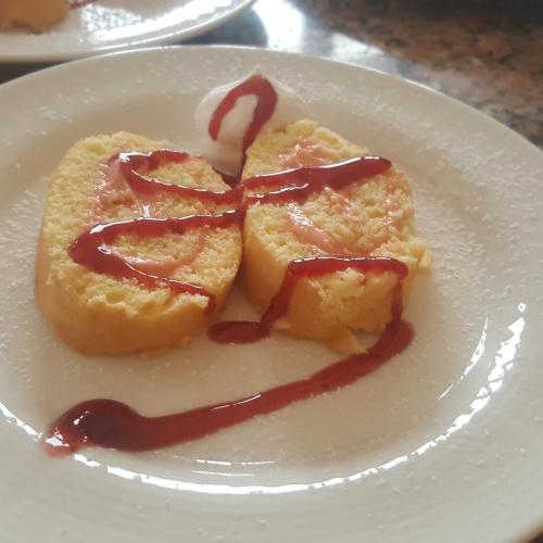 a white plate with a pastry with sauce on it at Hotel La Fattoria Sul Mare in Capo Vaticano