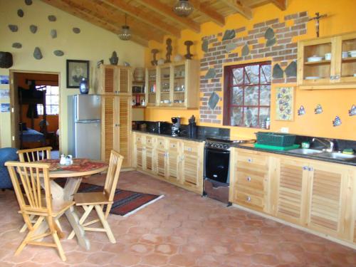 a kitchen with a table and chairs and a refrigerator at Casa Wenche in Santa Cruz La Laguna