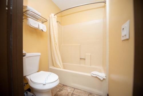 a bathroom with a toilet and a bath tub at Casa Bella Inn- Huntington Park in Huntington Park