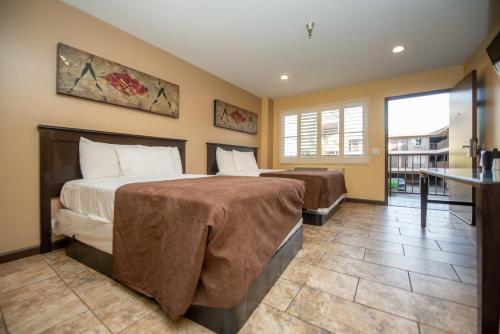 a bedroom with two beds and a balcony at Casa Bella Inn- Huntington Park in Huntington Park