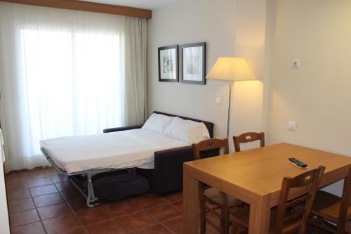 una stanza con un letto, un tavolo e una scrivania di Aparthotel Puerto Mar a Peñíscola