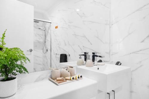 biała łazienka z umywalką i wanną w obiekcie Olinda Deluxe Apartment B1 w mieście Olinda