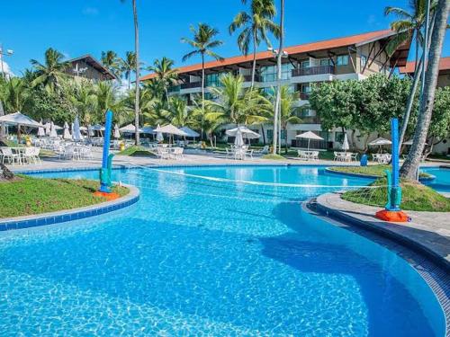 uma grande piscina num resort com palmeiras em Flats Marulhos Resort by BMS em Porto de Galinhas