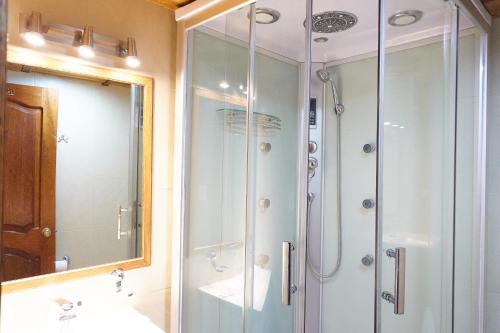 uma casa de banho com um chuveiro, um lavatório e um espelho. em Community Hostel Alausi em Alausí