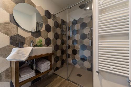 een badkamer met een wastafel en een douche met een spiegel bij parina Inn – Locanda in Camerata Cornello