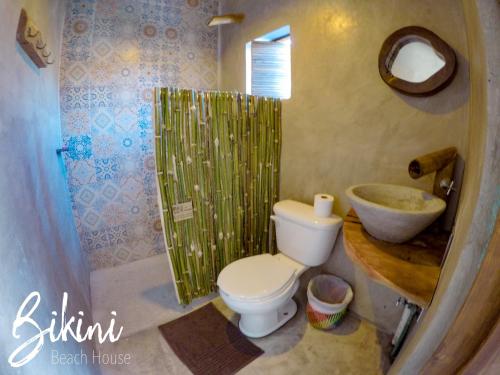 a bathroom with a white toilet and a sink at Bikini Beach House in Puerto Escondido