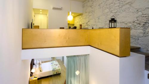 a wooden counter in a room with a stone wall at Bemyguest - Loft Guest House Jardim das Mães Charming in Viseu
