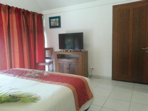 Una televisión o centro de entretenimiento en Hotel Hibiscus
