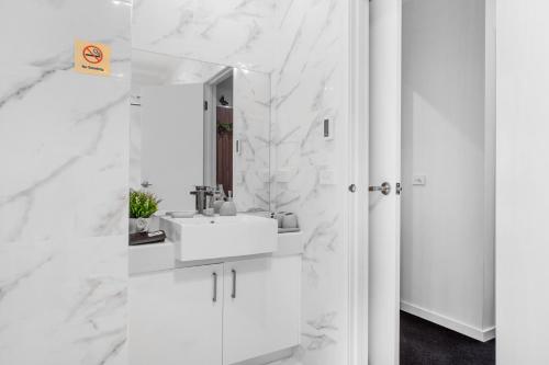 a white bathroom with a sink and a mirror at Olinda Two Bedroom Apartment - B2 in Olinda