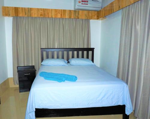a blue towel laying on a bed in a bedroom at Holiday Hire Fiji in Lautoka