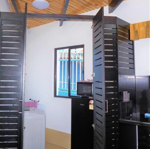 a kitchen with a black refrigerator and a window at Holiday Hire Fiji in Lautoka