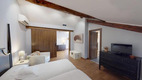 1 dormitorio con 1 cama y TV en una habitación en Villa Cornelius Lujo Rural 5 Estrellas Verdes, en Las Herencias